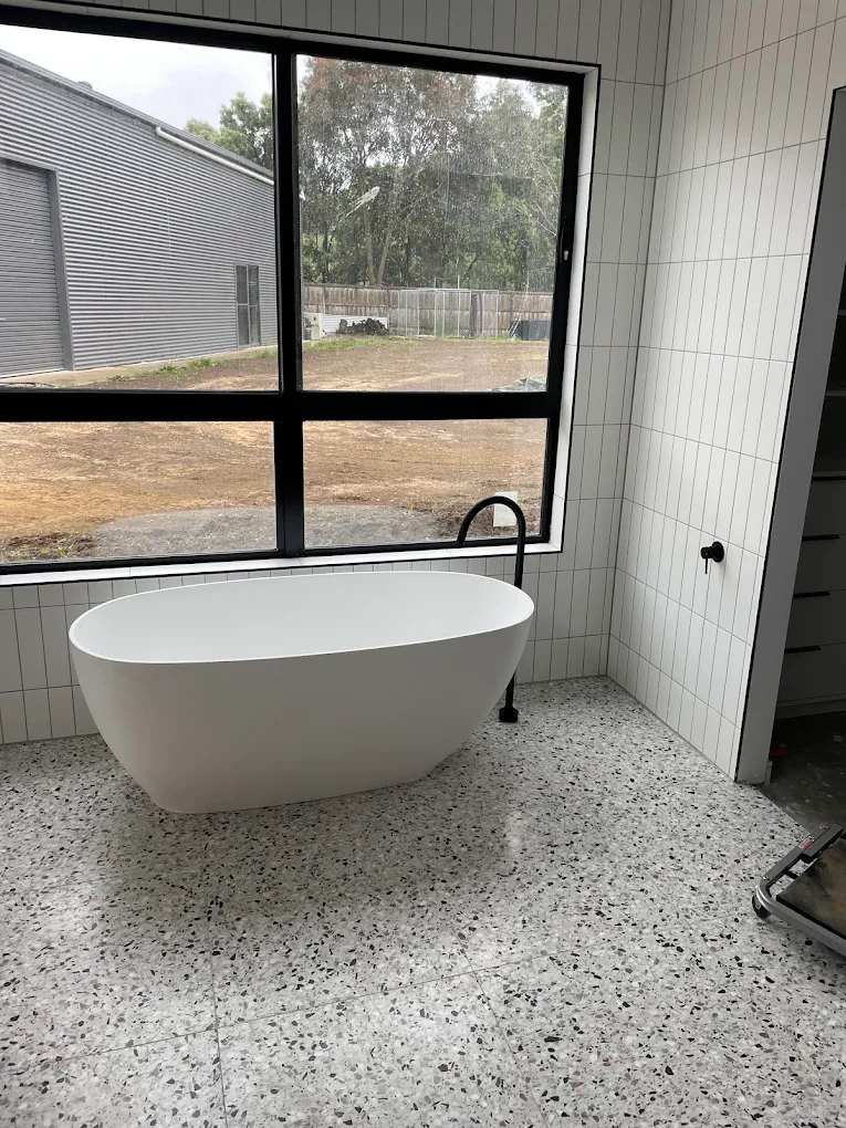 Freestanding bath and matte black mixer in a new build bathroom
