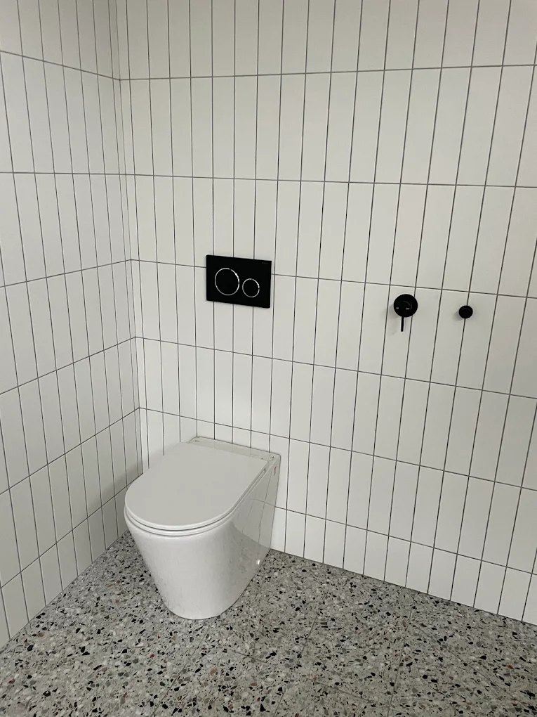Wall-hung toilet and concealed cistern, tiled out clean